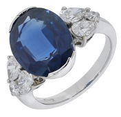 A sapphire and diamond ring, set with an oval-cut sapphire, weighing 7.56 carats, between shoulders set with...