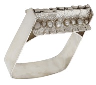 A silver bangle by Graham Watling, 1972, the shaped cuff with overlapping textured panels to the front, with...
