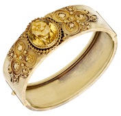 A citrine bangle by Bernhard Hertz, the oval-shaped citrine with trios of similarly-cut citrines to either side,...