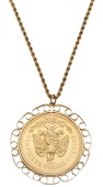 A coin pendant, the Mexican 50 pesos coin within a scrolled 9ct gold mount, rubbed London hallmark, suspended from a...