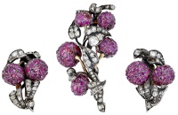 A ruby and diamond brooch and ear clips, modelled as foliate sprays, the bombé highlights set with oval mixed-cut...