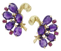A pair of amethyst and ruby ear clips, modelled as stylised feathers, set with vari-cut amethysts with ruby cabochon...
