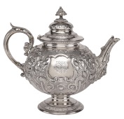 A Victorian silver teapot, the globular body repoussé decorated in high relief with flowerheads, fruit, leaves and...