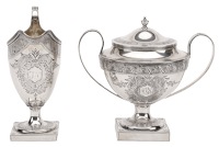 A silver helmet-shaped cream jug and matching lidded sugar vase, with bands of bright-cut decoration, reeded...