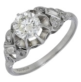 An Art Deco diamond ring, set with an old brilliant-cut diamond in a raised claw setting, between openwork shoulders...