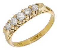 A diamond five stone ring, 1918, set with a graduated row of old brilliant-cut diamonds, to a carved scroll gallery,...