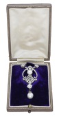 An early 20th century pearl and diamond pendant, French, set with two old cushion-shaped diamonds suspending an...
