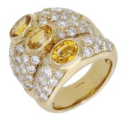 A yellow sapphire and diamond dress ring, of triple hoop design, each set with an oval-cut yellow sapphire between...