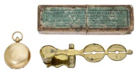 An 18ct gold sovereign case and a set of brass sovereign / half sovereign balance scales, the sovereign case by...