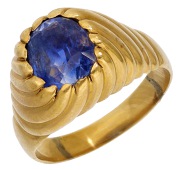 A mid 20th century Sri Lankan sapphire ring, the cushion-cut sapphire within  a reeded mount, to plain polished...