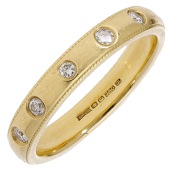 An 18ct gold and diamond eternity ring, the polished band inlaid with brilliant-cut diamonds, with engraved...