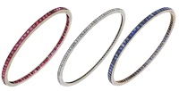 A set of three Art Deco gem-set bangles, set throughout with step-cut rubies, sapphires or rose-cut diamonds, the...