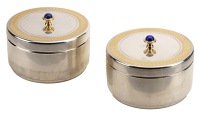 A pair of Elizabeth II silver and parcel gilt circular boxes and covers, with textured bodies, each lid with a...