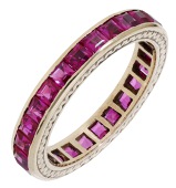 A synthetic ruby eternity ring, set with calibré-cut rubies in a mount with engraved zigzag detail, stamped...