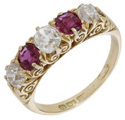 A ruby and diamond five stone ring, 1901, set with circular-cut rubies and old brilliant-cut diamonds, to a carved...