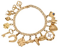 A charm bracelet, the curb-link chain suspending various charms to include two four-leaf clovers, a camel, an...
