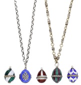A collection of five egg pendants, decorated in vari-coloured enamels, the blue example opening to reveal a locket...