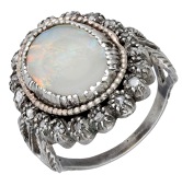 An antique opal and diamond cluster ring, the opal cabochon within a surround of rose-cut diamonds, to bifurcated...