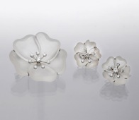 A rock crystal and diamond flowerhead brooch and earring suite, circa 1950, the realistically carved flower with...