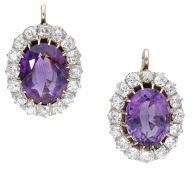 A pair of amethyst and diamond cluster earrings, the oval mixed-cut amethysts within a surround of old brilliant-cut...
