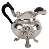 A French silver milk jug, with broad pouring rim, globular body, ebonised handle and scroll feet, engraved with...