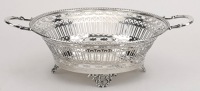 A George V twin handled silver sweetmeat basket, with ‘C’ shaped handles and pierce-decorated sides and feet, by...