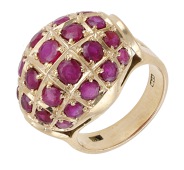 A ruby dress ring, circa 1960, of bombé design and set with circular-cut rubies, between looped shoulders, stamped...
