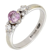 A pink sapphire and diamond ring by Ingeborg Bratman, 2000, set with a circular-cut pink sapphire between two...