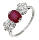 A Burmese ruby and diamond three stone ring, the cushion-cut ruby between old brilliant and transitional-cut...