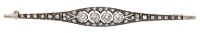 An early 20th century diamond bar brooch, the tapered plaque set with four old brilliant-cut diamonds within a...