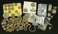 A large assorted group of mainly British military cap badges, buttons, shoulder pips etc., together with a small...